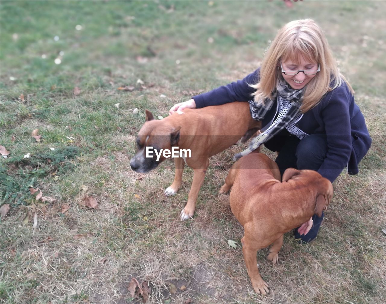 WOMAN WITH DOG ON FIELD DURING RAINY SEASON