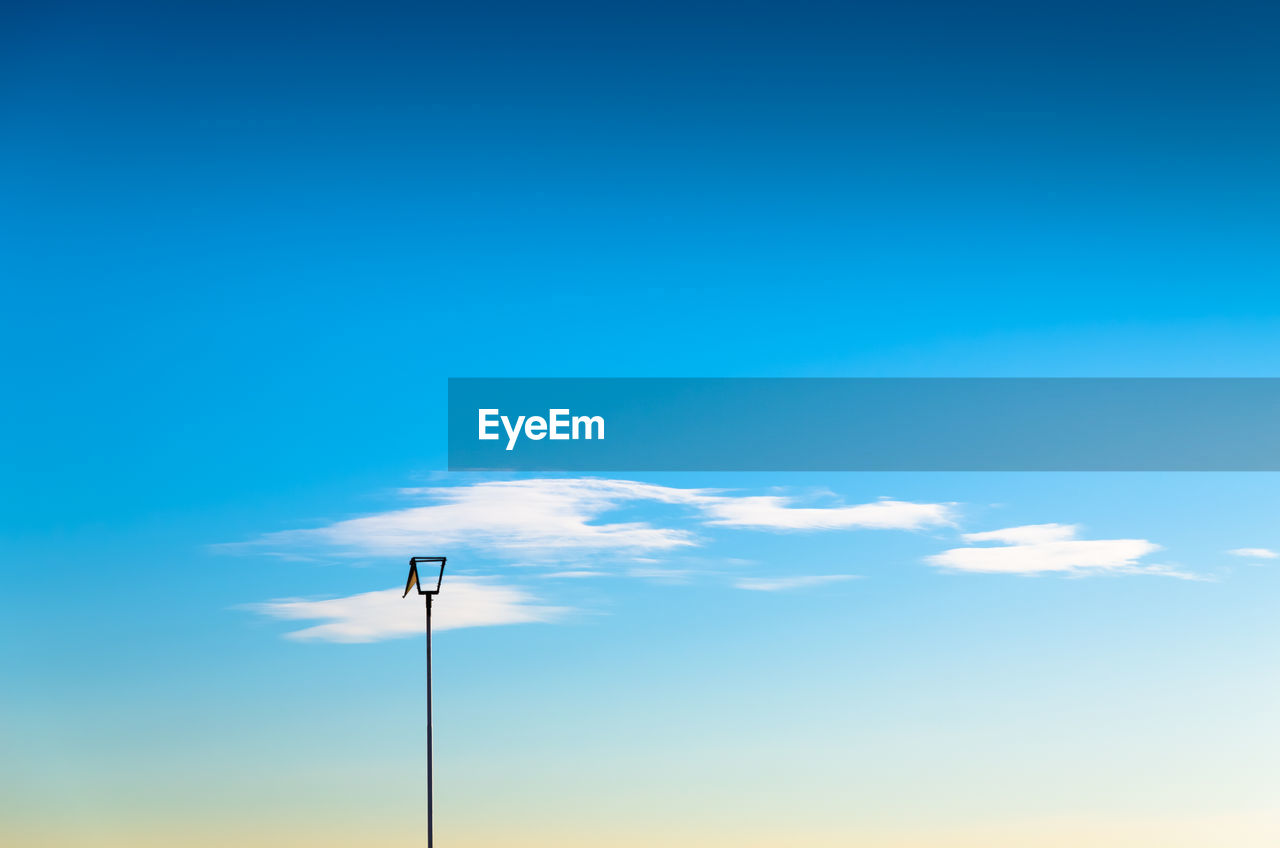 Low angle view of lamp post against blue sky