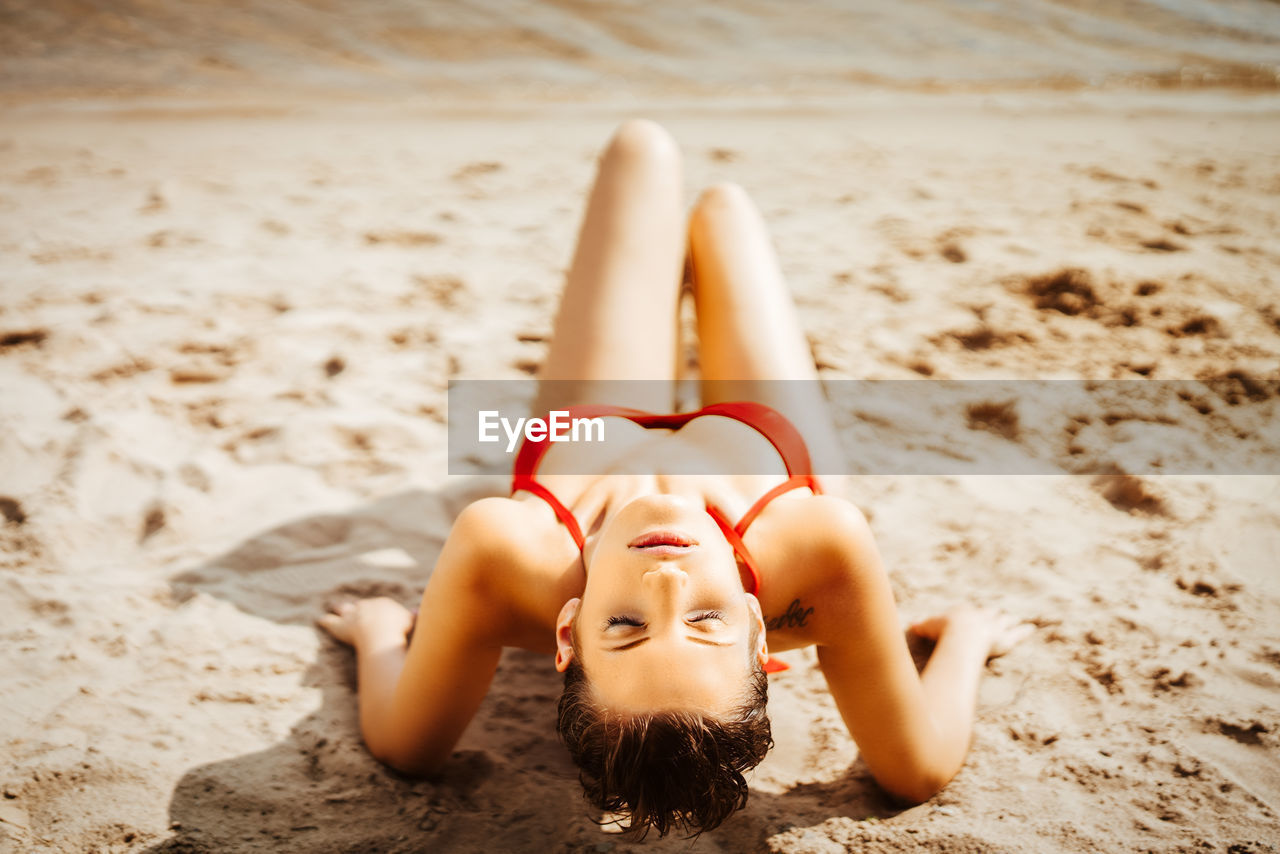 High angle view of sensuous model in bikini posing at beach