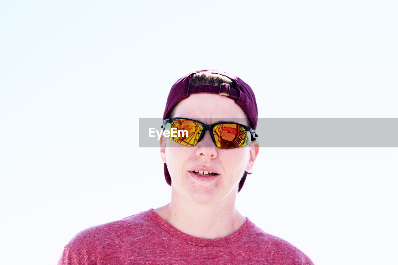 Portrait of young man in sunglasses against clear sky