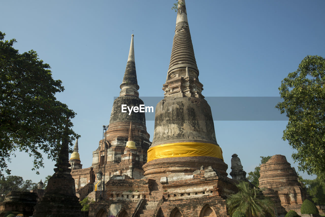 Low angle view of buddhist temple against clear blue sky