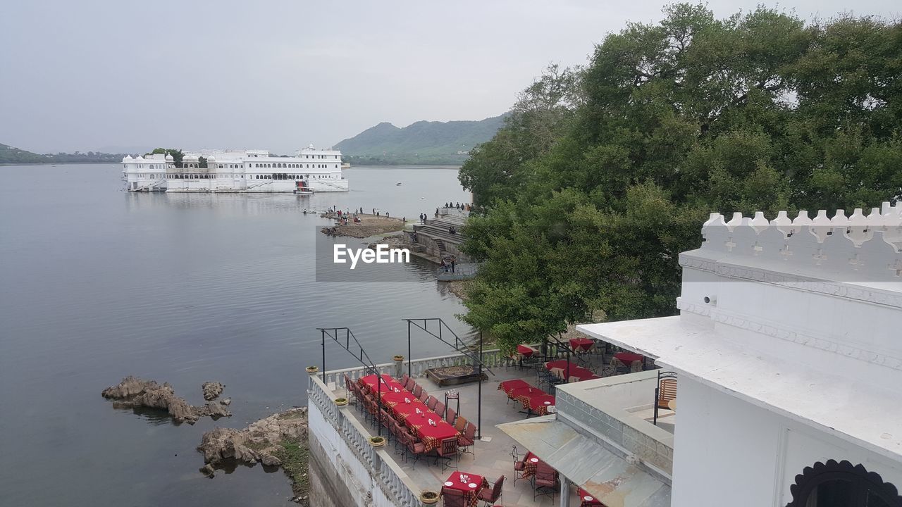 High angle view of taj lake palace from lake pichola against the sky.