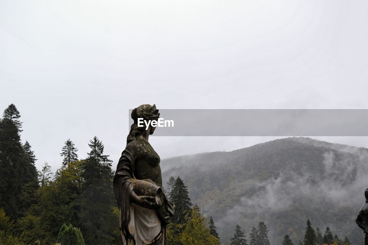 Statue on mountain against sky