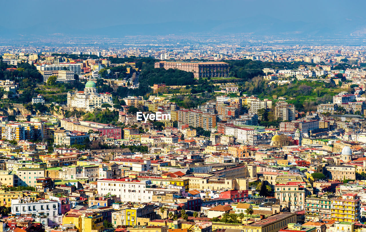 HIGH ANGLE VIEW OF CITYSCAPE AGAINST SKY