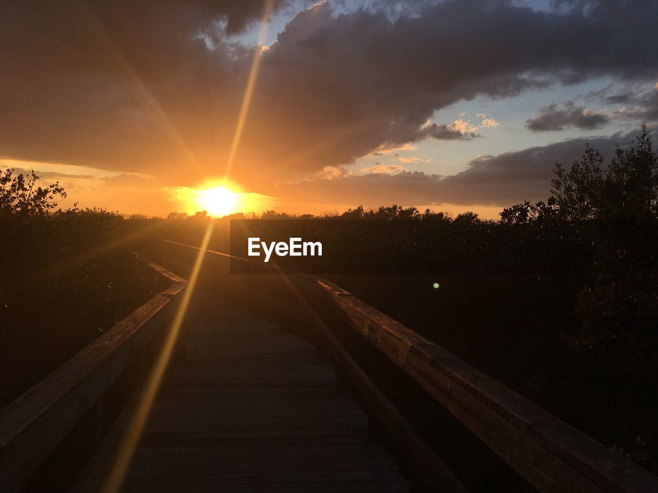 Railroad tracks against sky during sunset