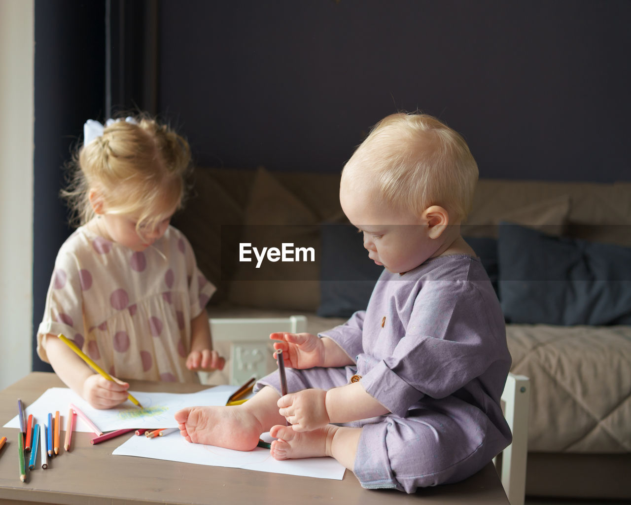 Two kids brother and sister drawing and playing together at home