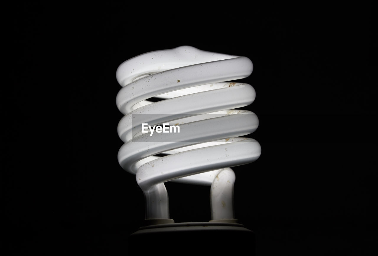 Close-up of energy efficient lightbulb against black background