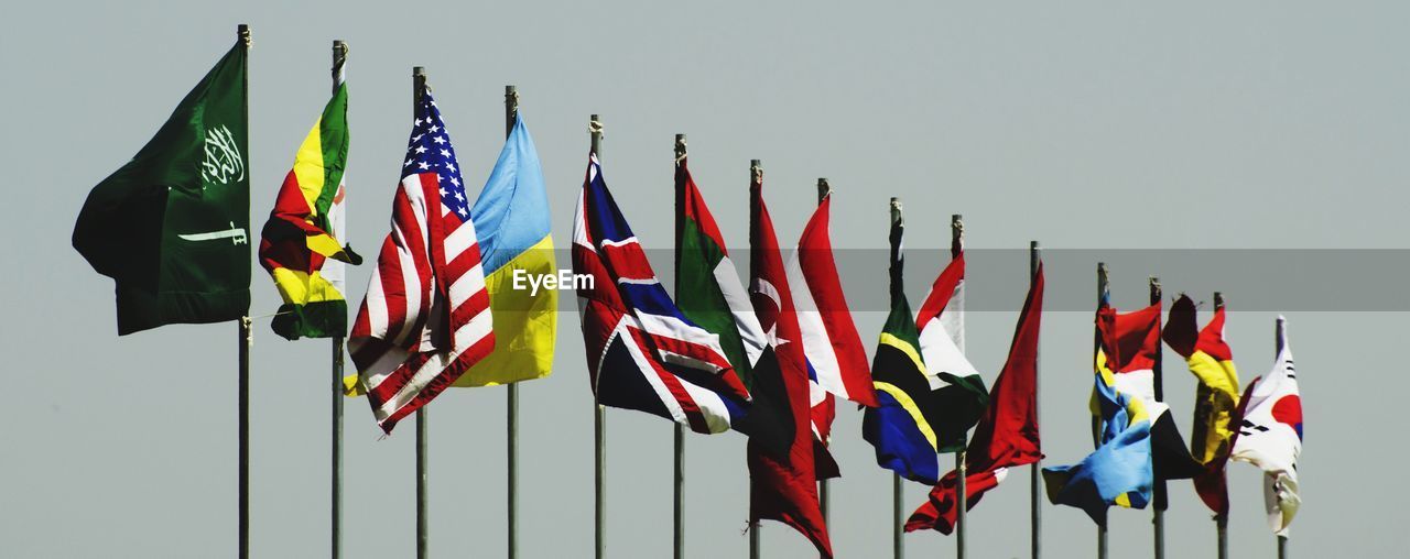 Low angle view of flags against clear sky