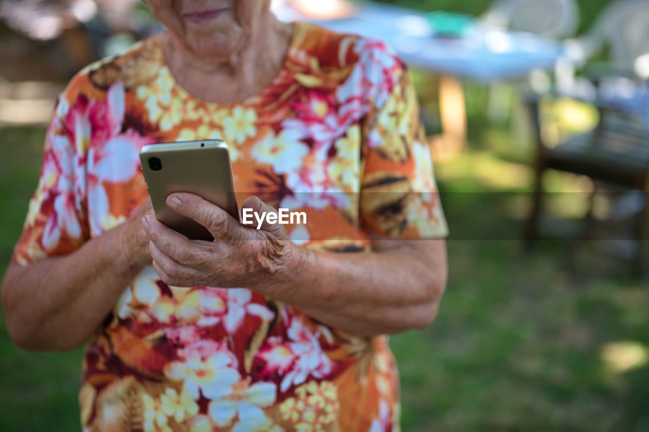 Midsection of senior woman using mobile phone