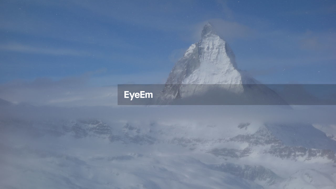 Snow covered landscape against sky