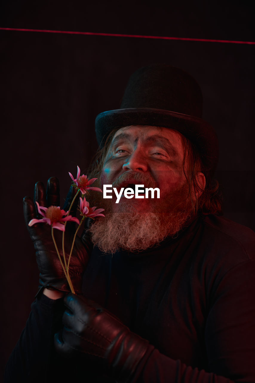 adult, one person, facial hair, men, beard, portrait, red, hat, music, performance, performing arts, entertainment, clothing, indoors, stage, concert, headshot, emotion, black background, studio shot, person, mature adult, darkness, musician, dark, night, senior adult, waist up, mouth open