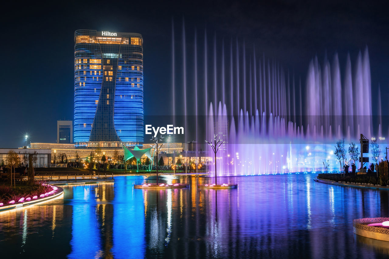 ILLUMINATED BUILDINGS AT WATERFRONT