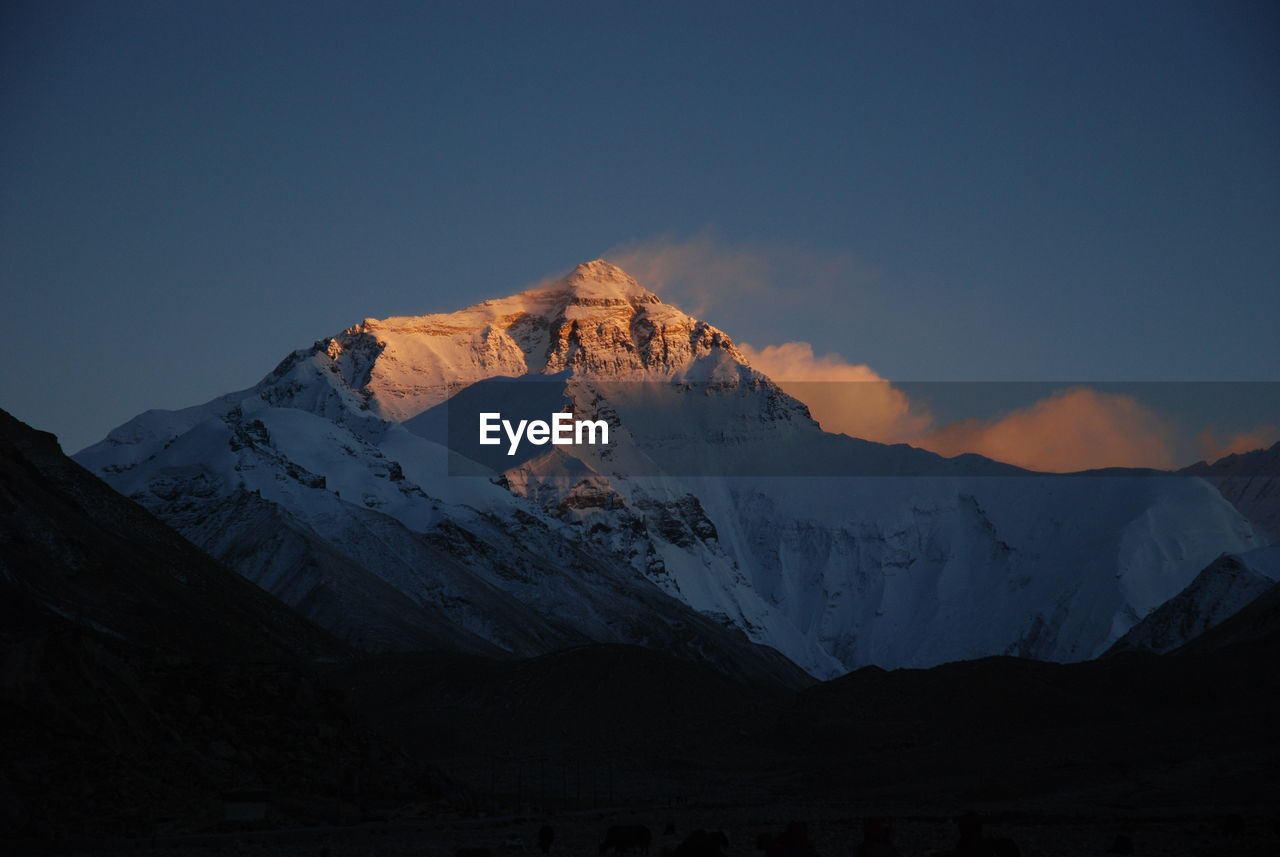 Scenic view of snowcapped mountains against sky during sunset