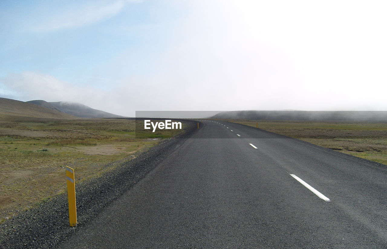 Empty road along countryside landscape