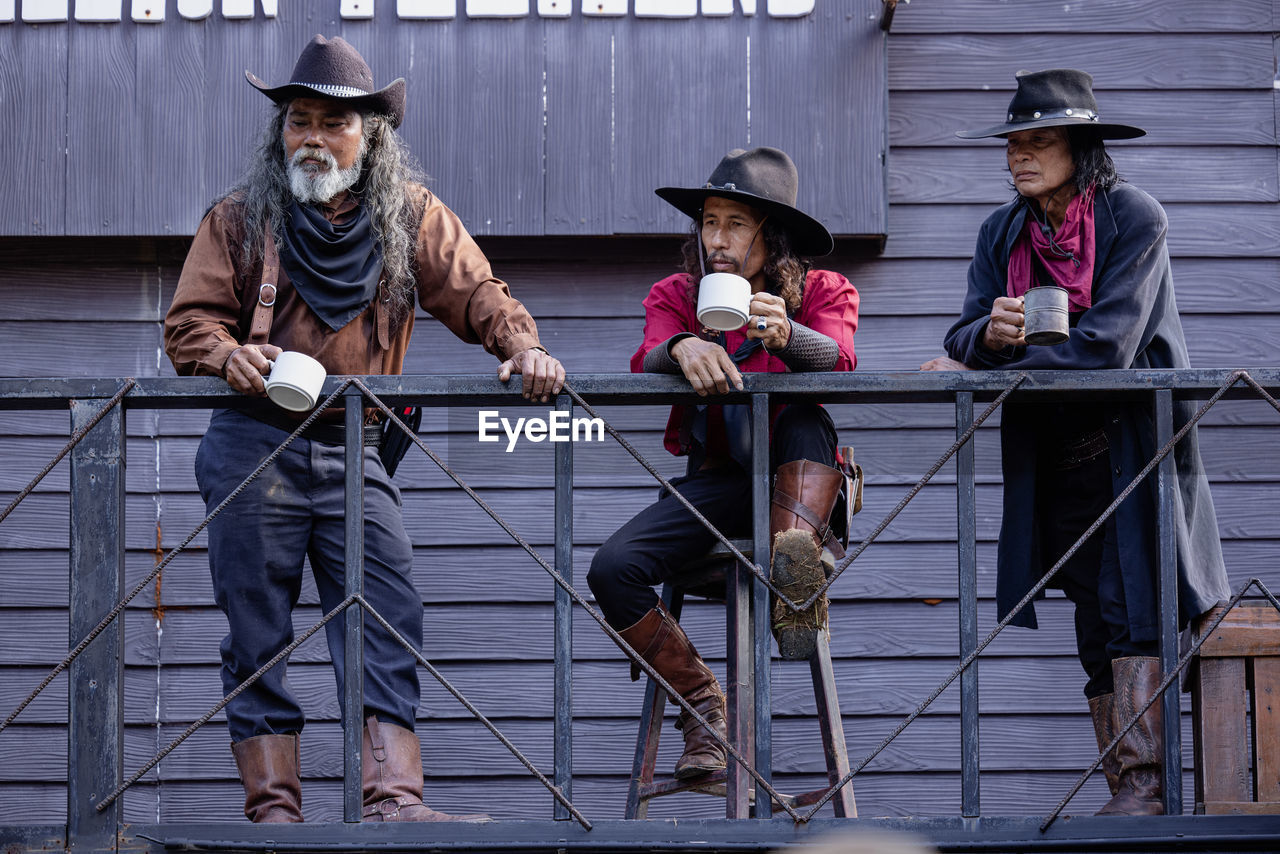Early morning portrait of senior cowboys drinking coffee