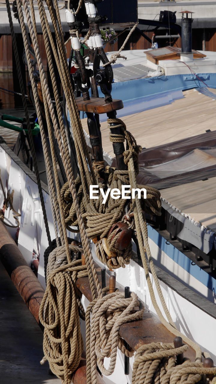 HIGH ANGLE VIEW OF ROPE TIED TO HARBOR