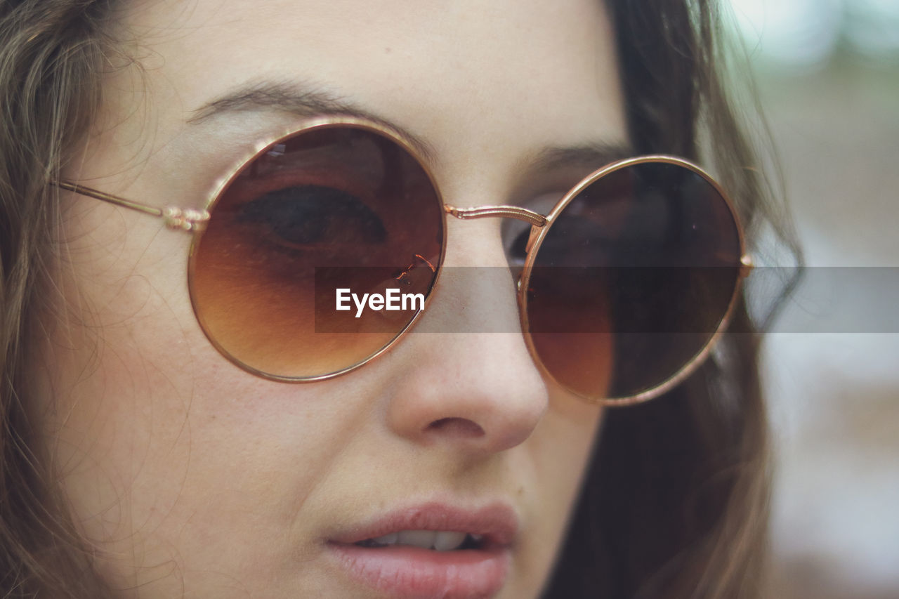 Close-up portrait of beautiful young woman wearing sunglasses