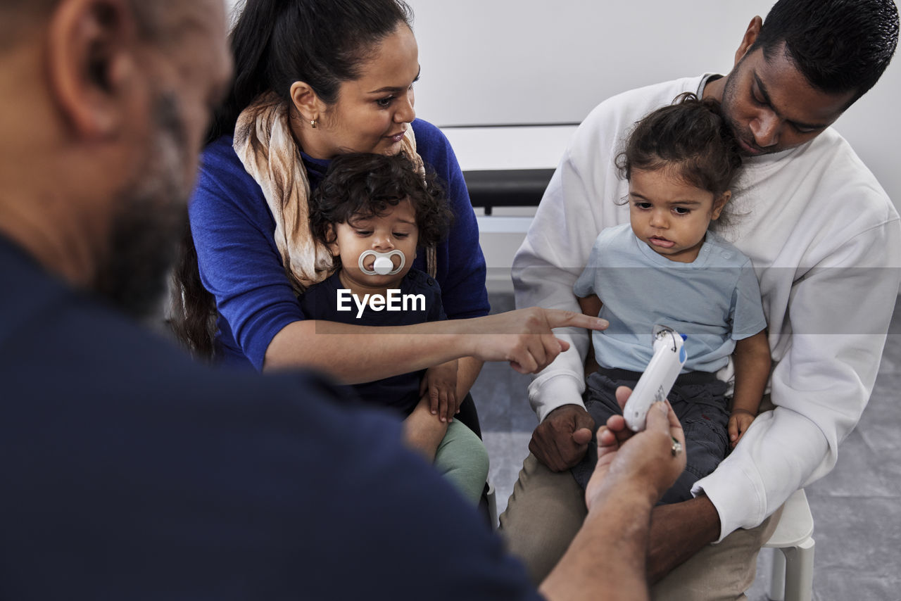 Male doctor examining family with children