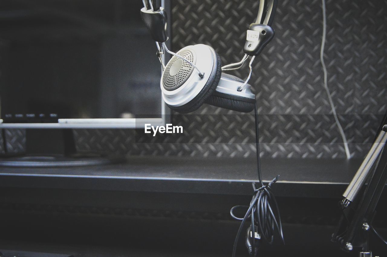 Close-up of headphones and television at recording studio