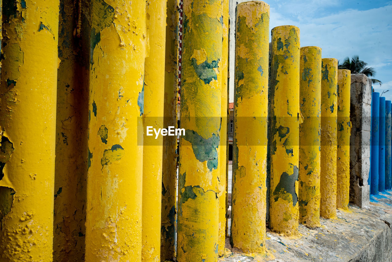 CLOSE-UP OF YELLOW METAL AGAINST WALL