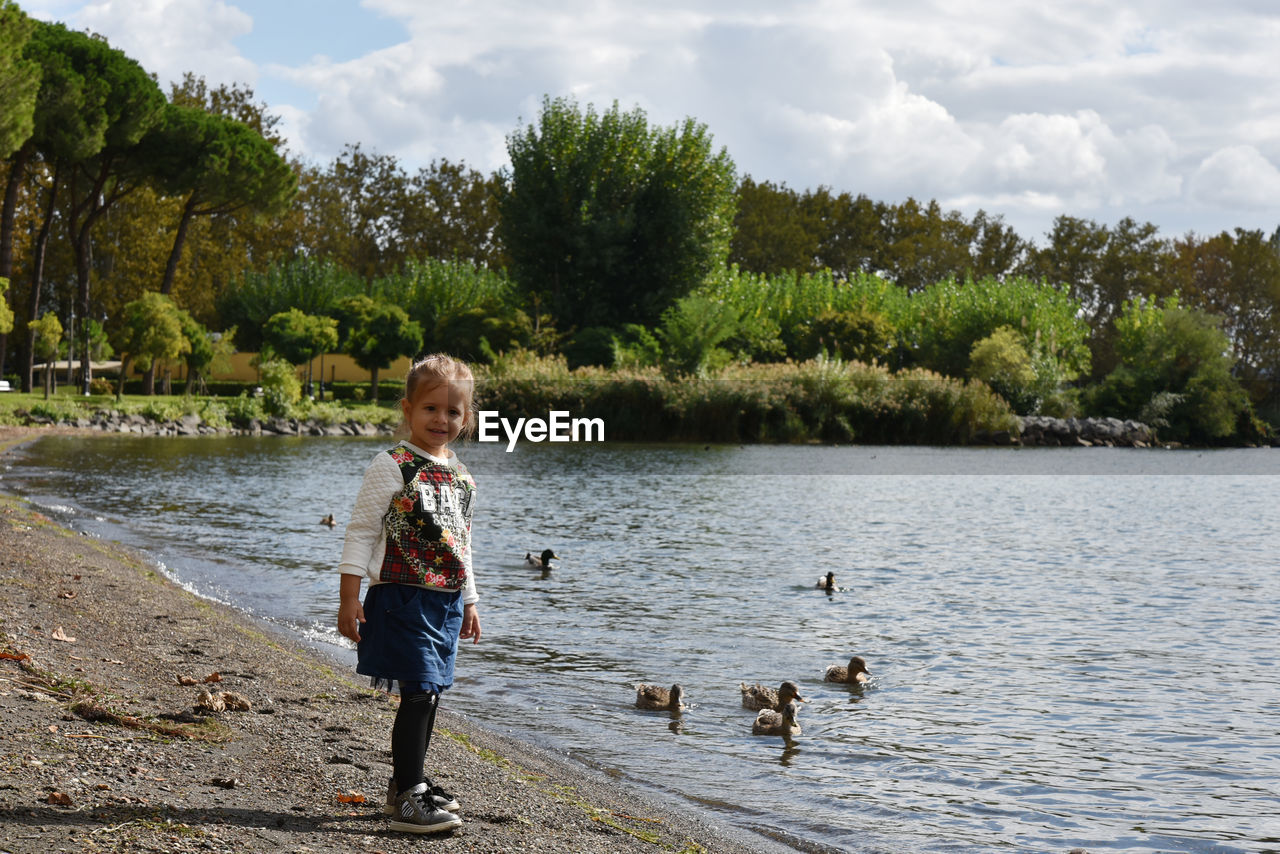 Portrait of smiling girl standing at lakeshore