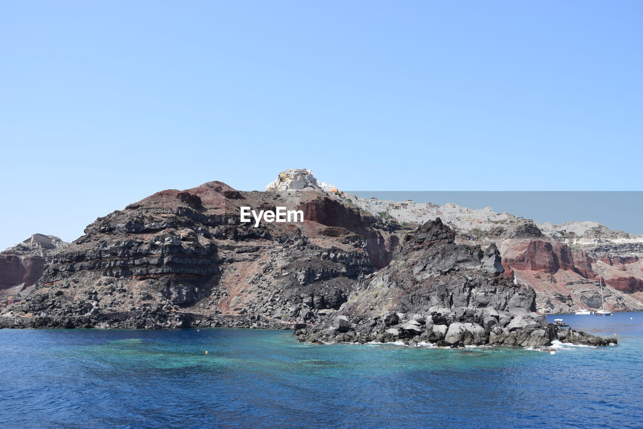 ROCK FORMATION IN SEA AGAINST CLEAR SKY