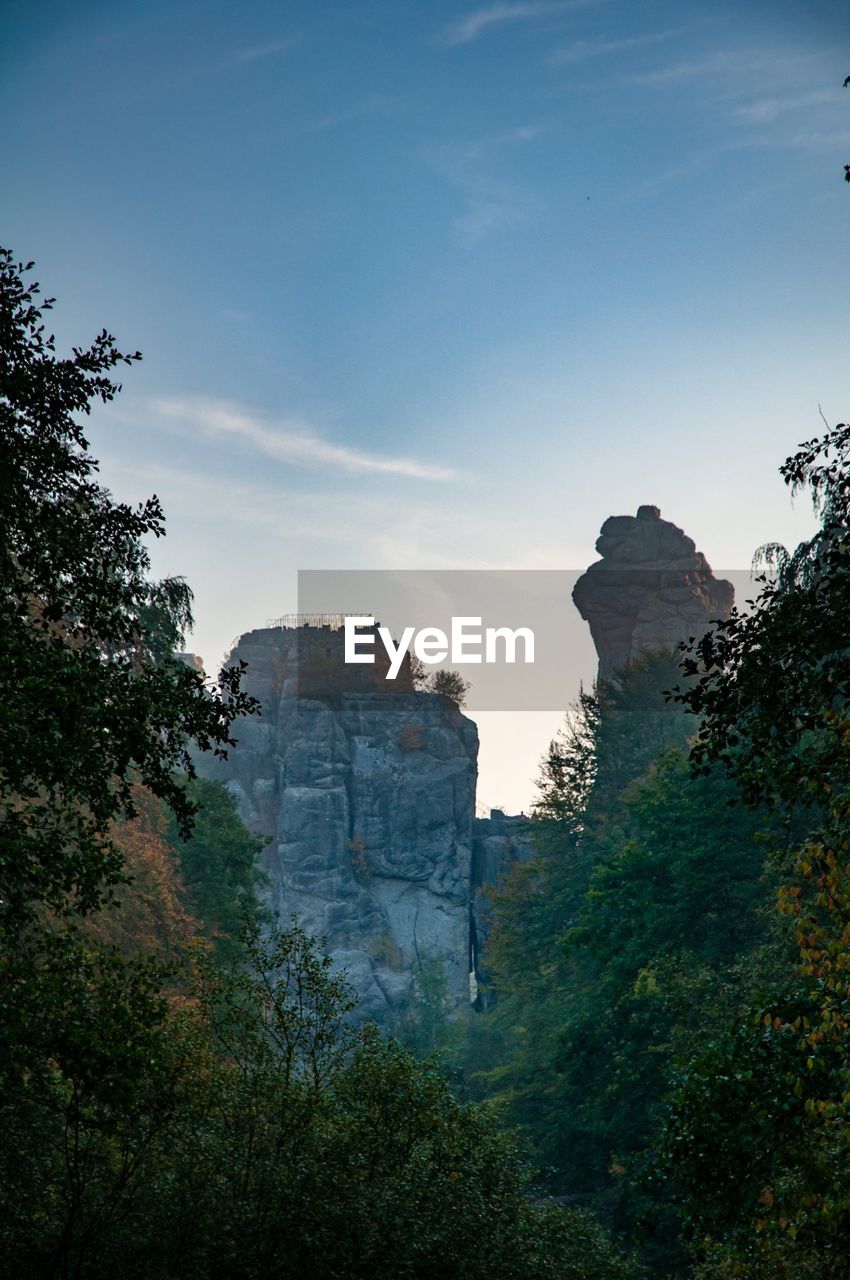 Rock formation and trees against sky