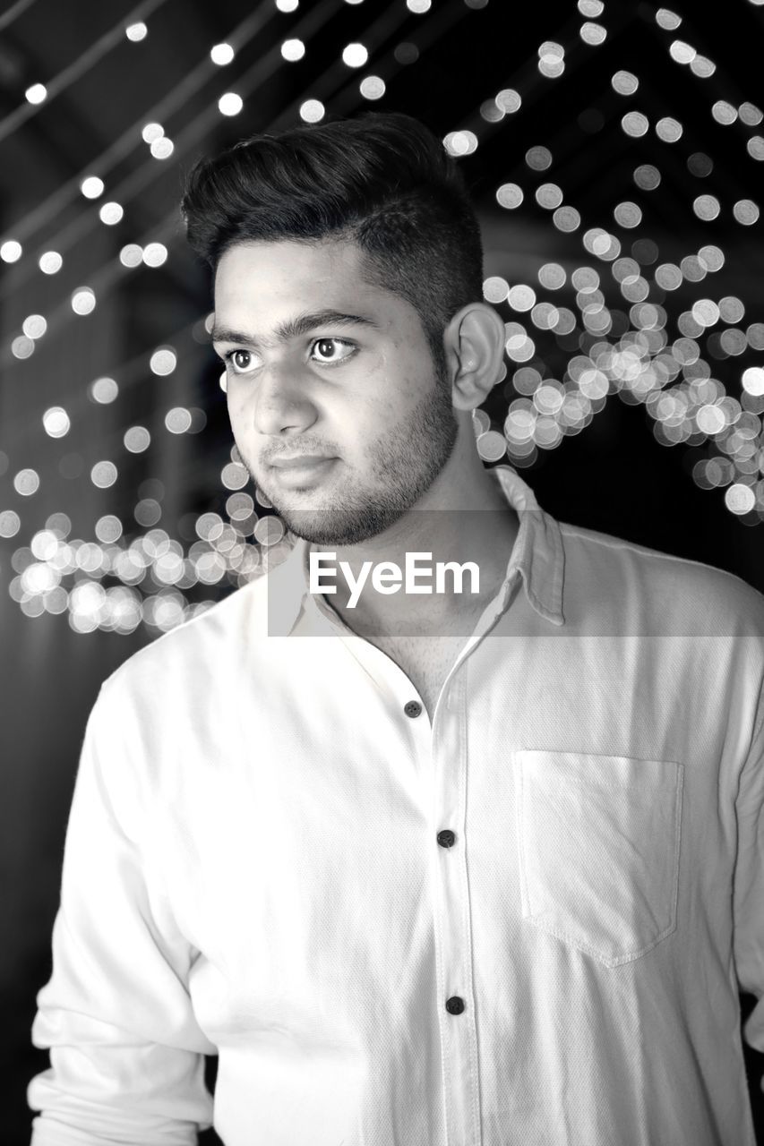 Portrait of young man standing at night