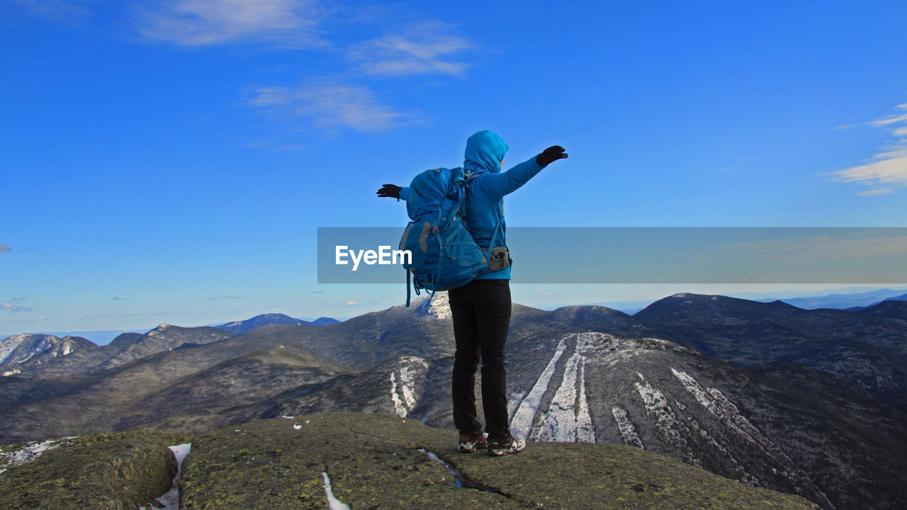 Man standing on mountain against blue sky