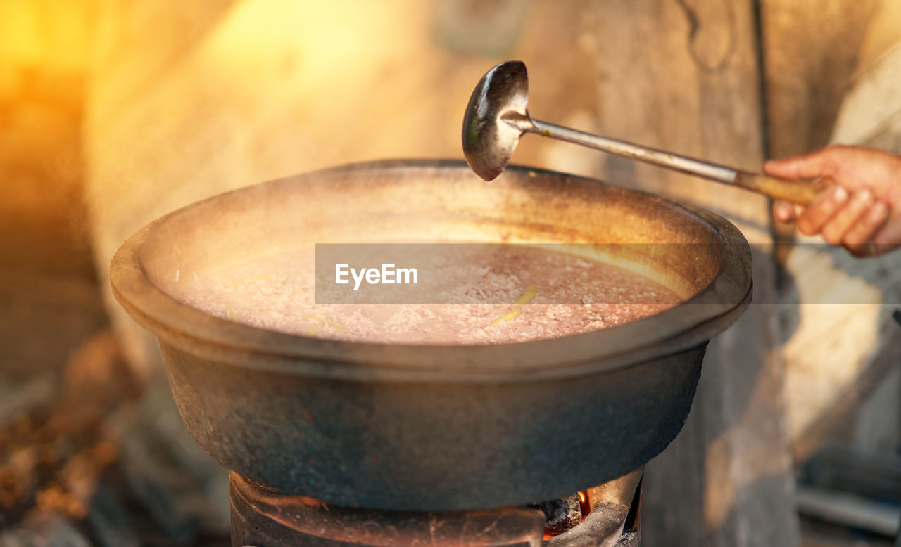 Close-up of hand holding ladle cook soup