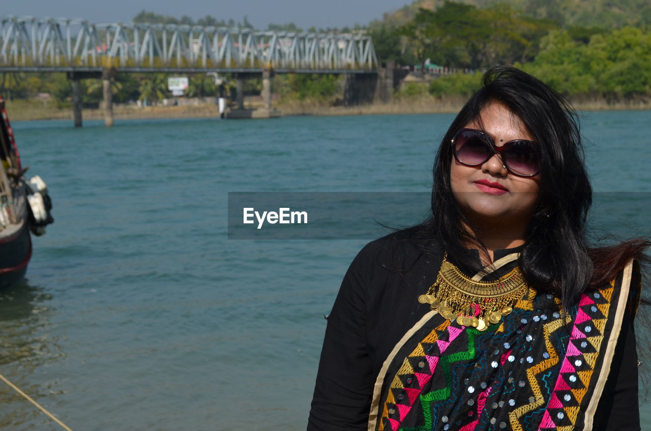 Portrait of woman wearing sari standing against sea