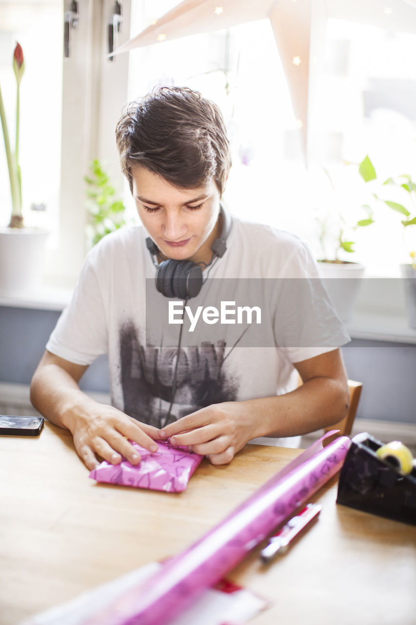 Teenage boy wrapping present