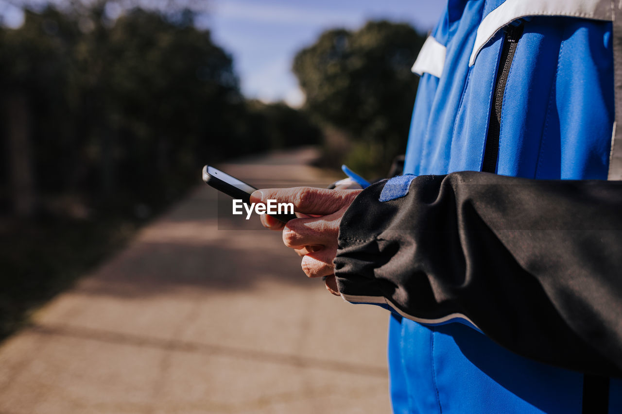 Midsection of man using phone outdoors