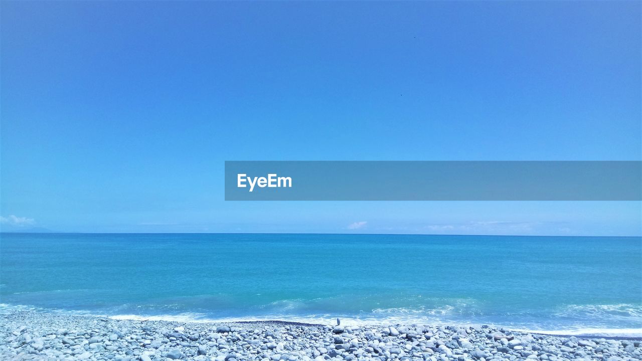 Scenic view of sea against clear blue sky