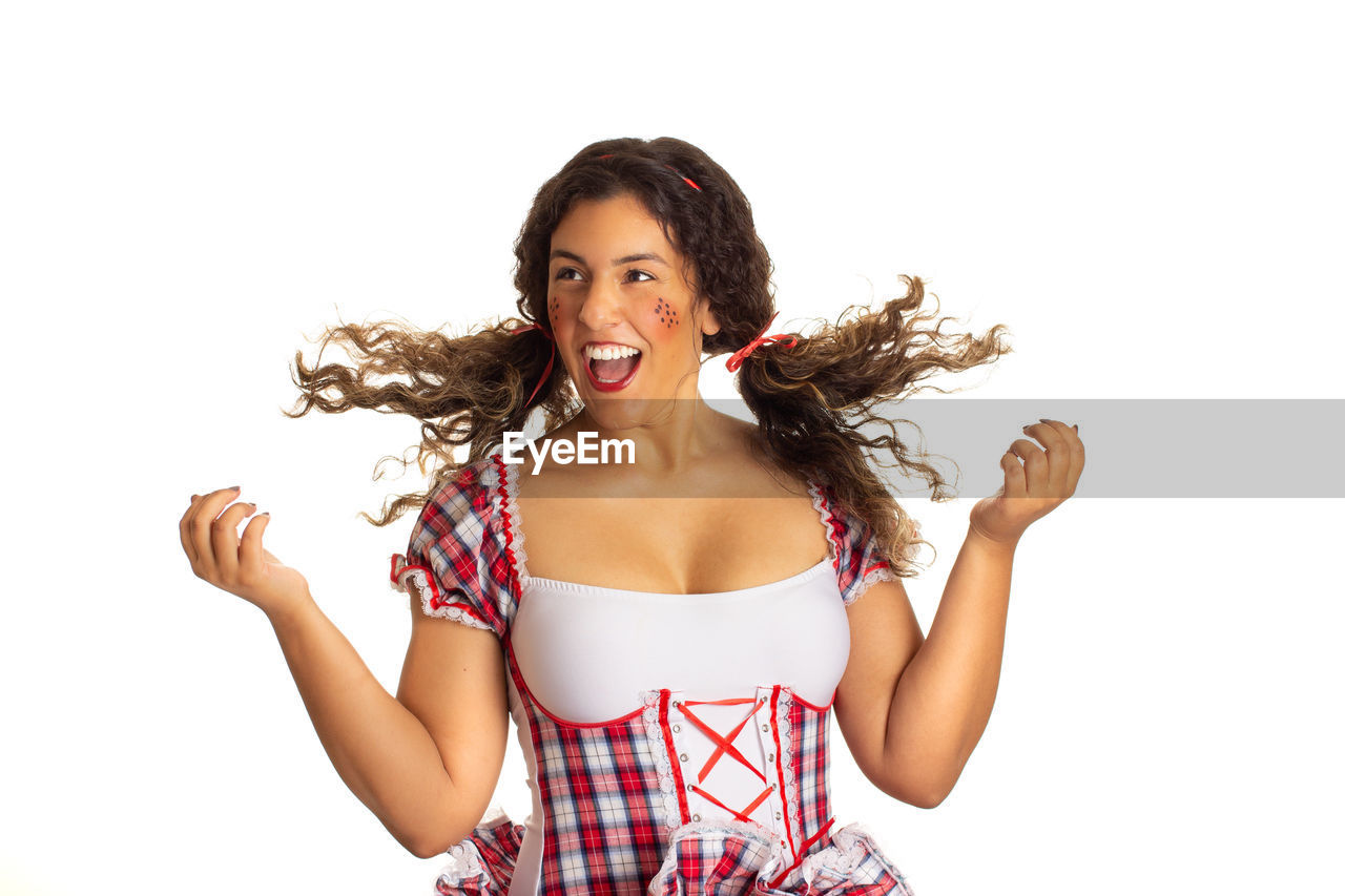 PORTRAIT OF A SMILING YOUNG WOMAN OVER WHITE BACKGROUND