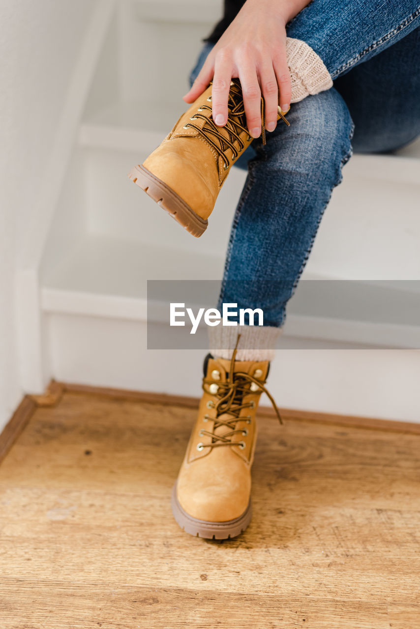 A young woman in autumn clothes is getting ready for a walk. the girl wears shoes.