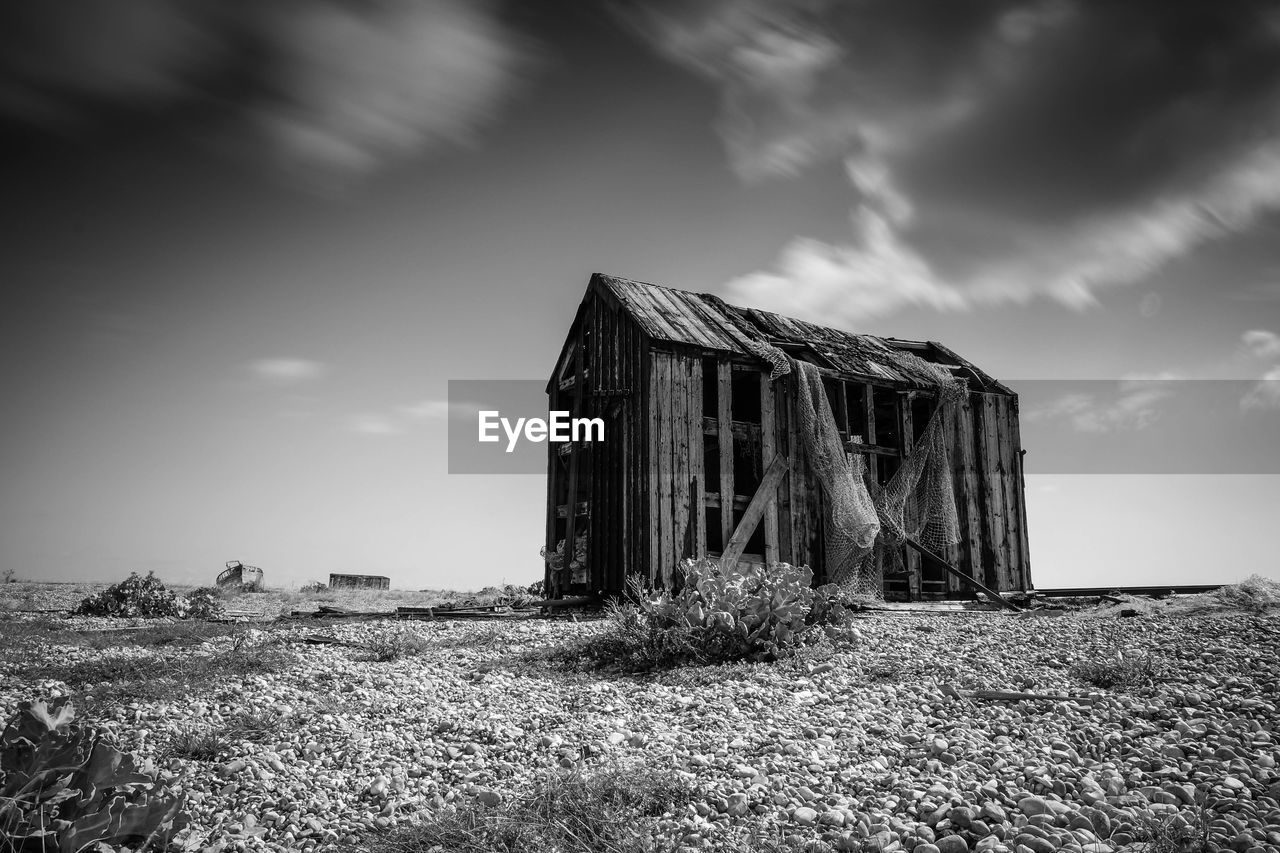 Abandoned building against cloudy sky