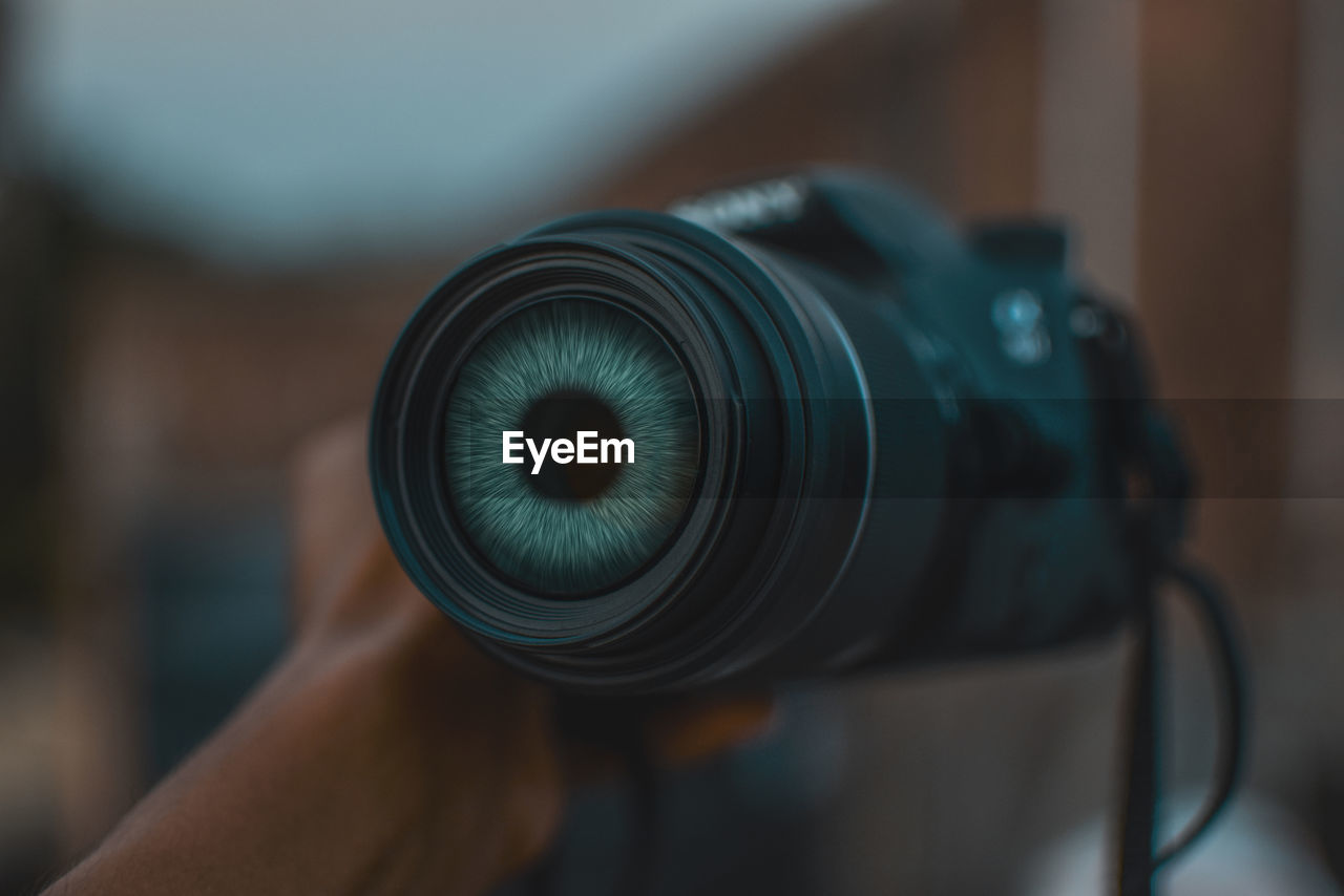 Cropped hand of man holding camera