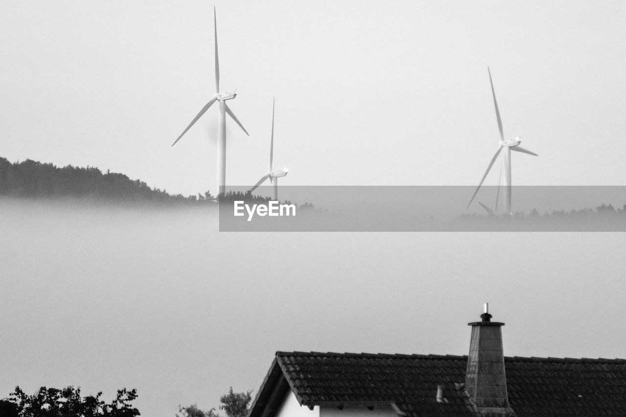 Windmill on landscape against clear sky