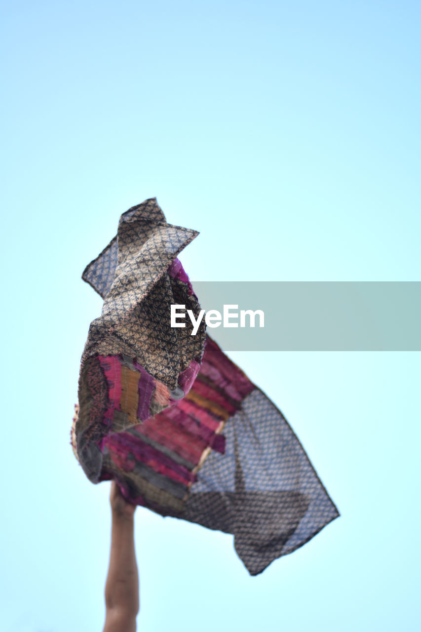 LOW ANGLE VIEW OF PERSON AGAINST BLUE SKY