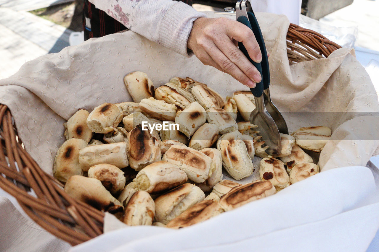 CLOSE-UP OF HAND HOLDING BURGER