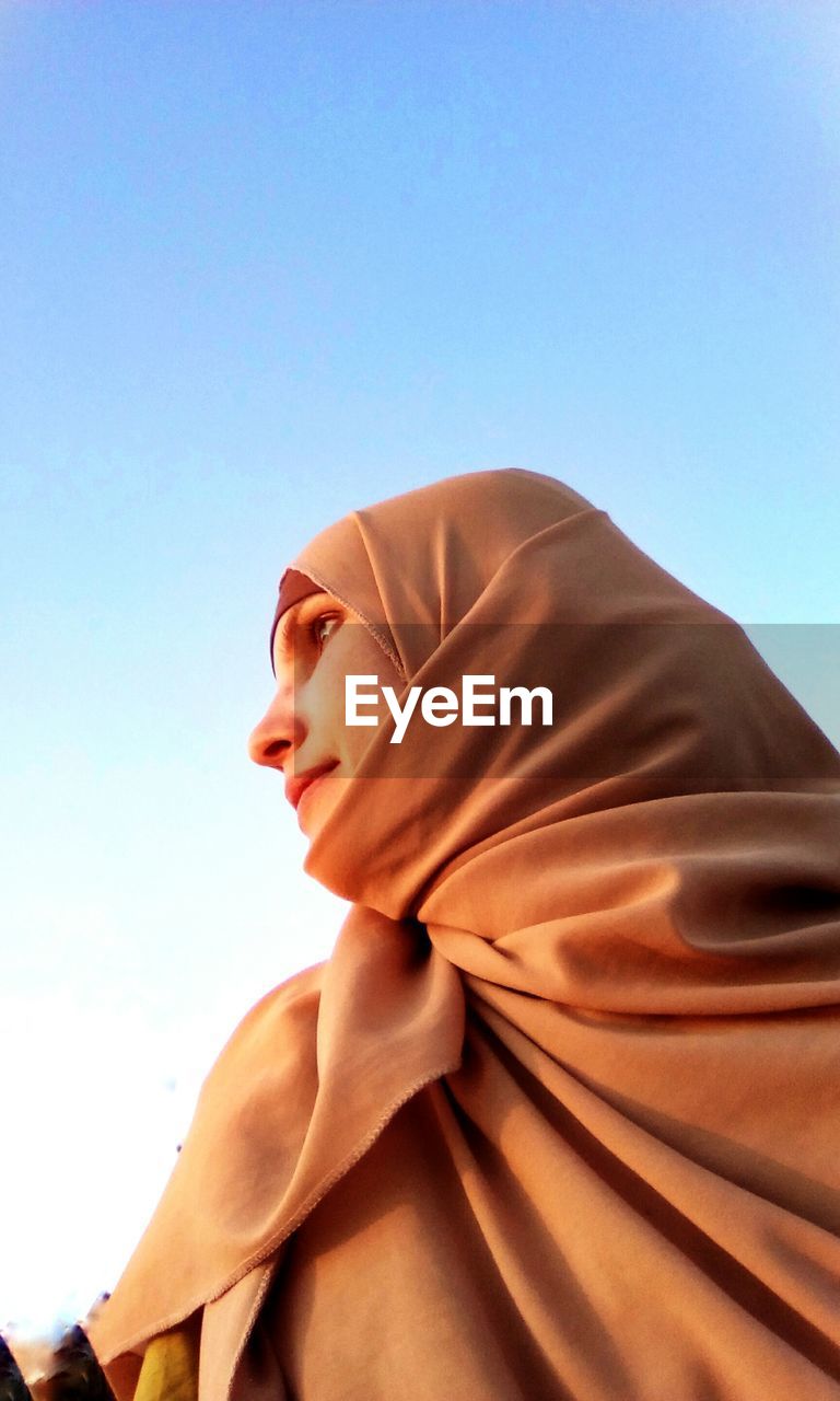 Low angle view of woman against clear sky
