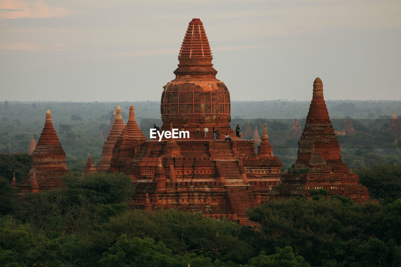 People at stupa against sky