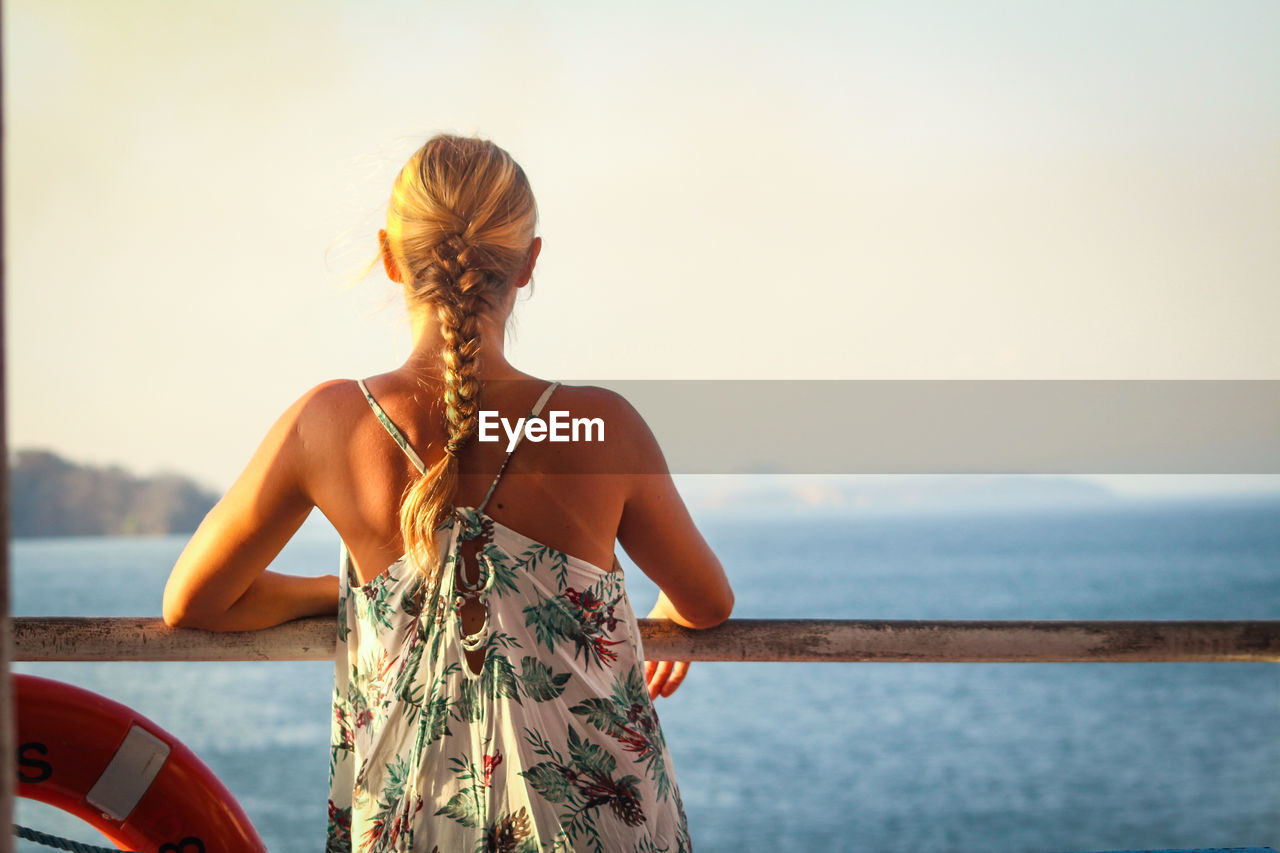 Rear view of woman looking at sea against sky