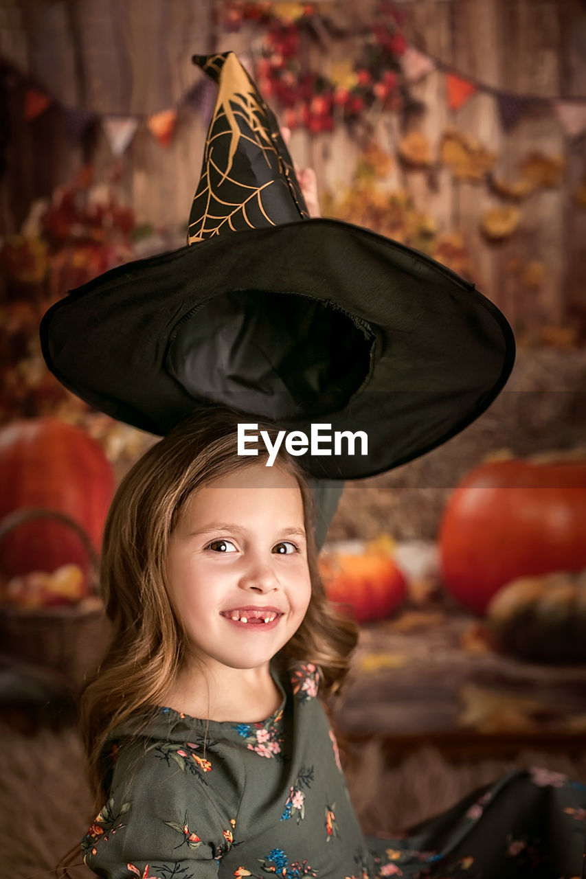 Happy halloween. a beautiful 6-7-year-old girl tries on a witch hat. going to the halloween party. 