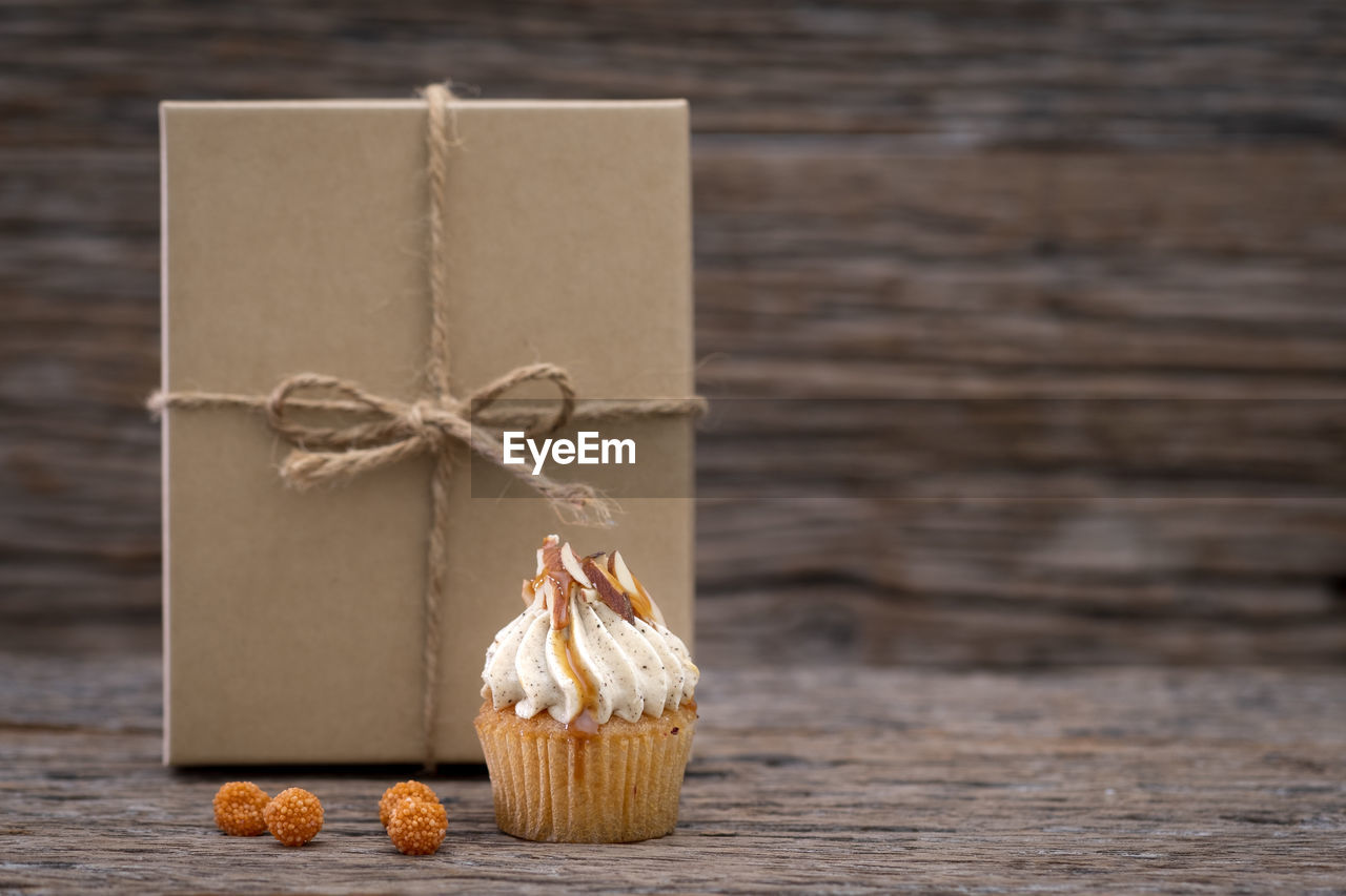 Close-up of cupcake and christmas present on table
