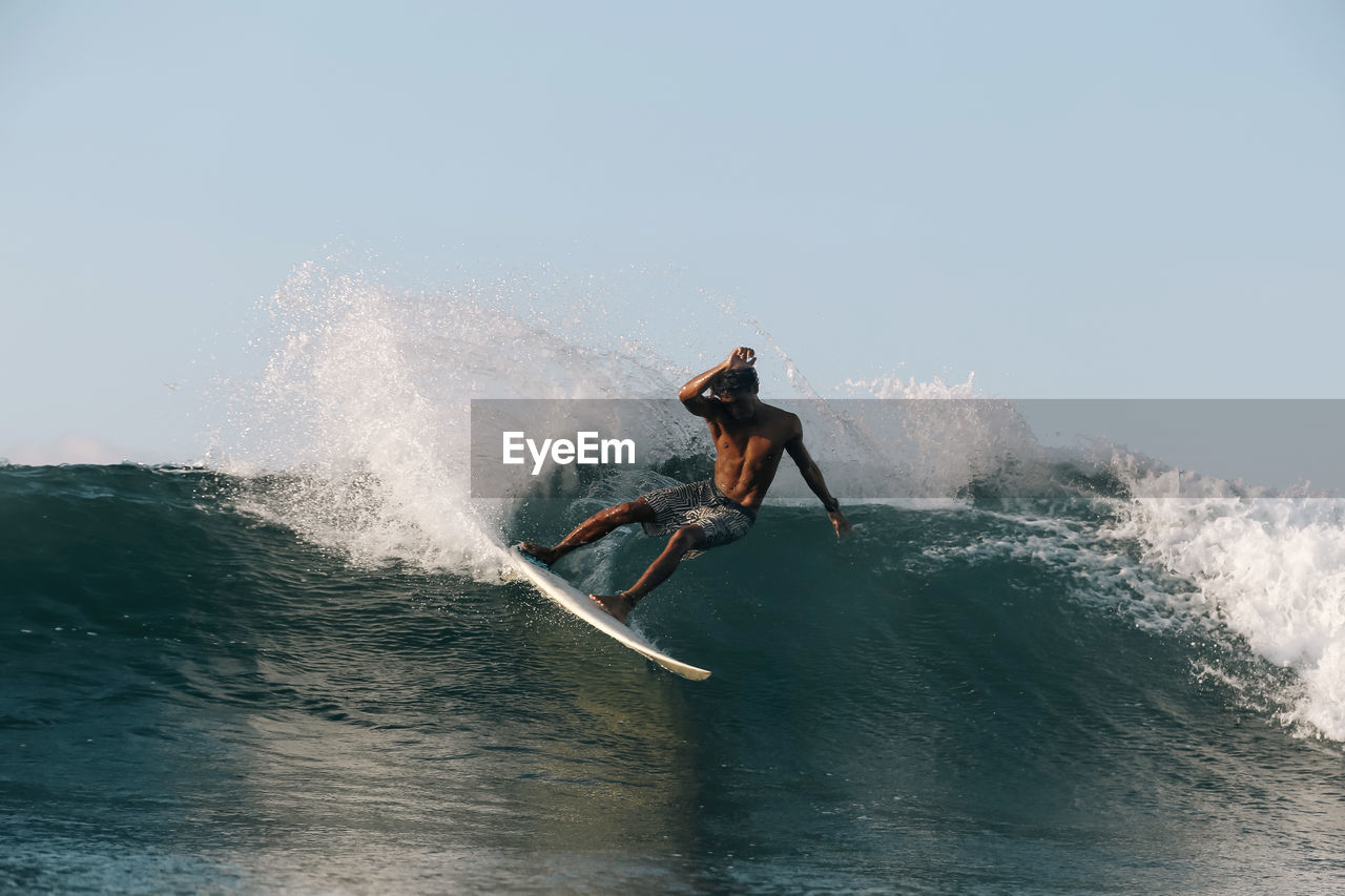 Surfer on a wave at sunny day