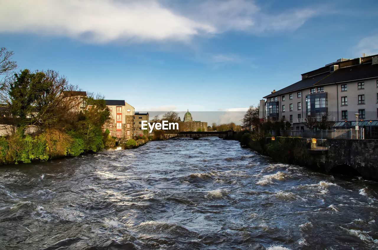 River amidst buildings against sky in city