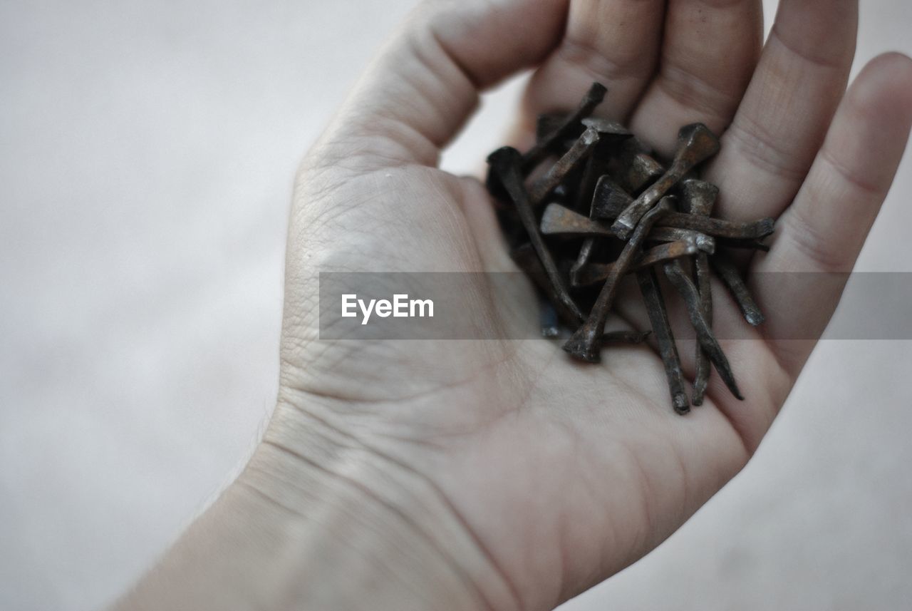 CLOSE-UP OF HUMAN HAND HOLDING RING