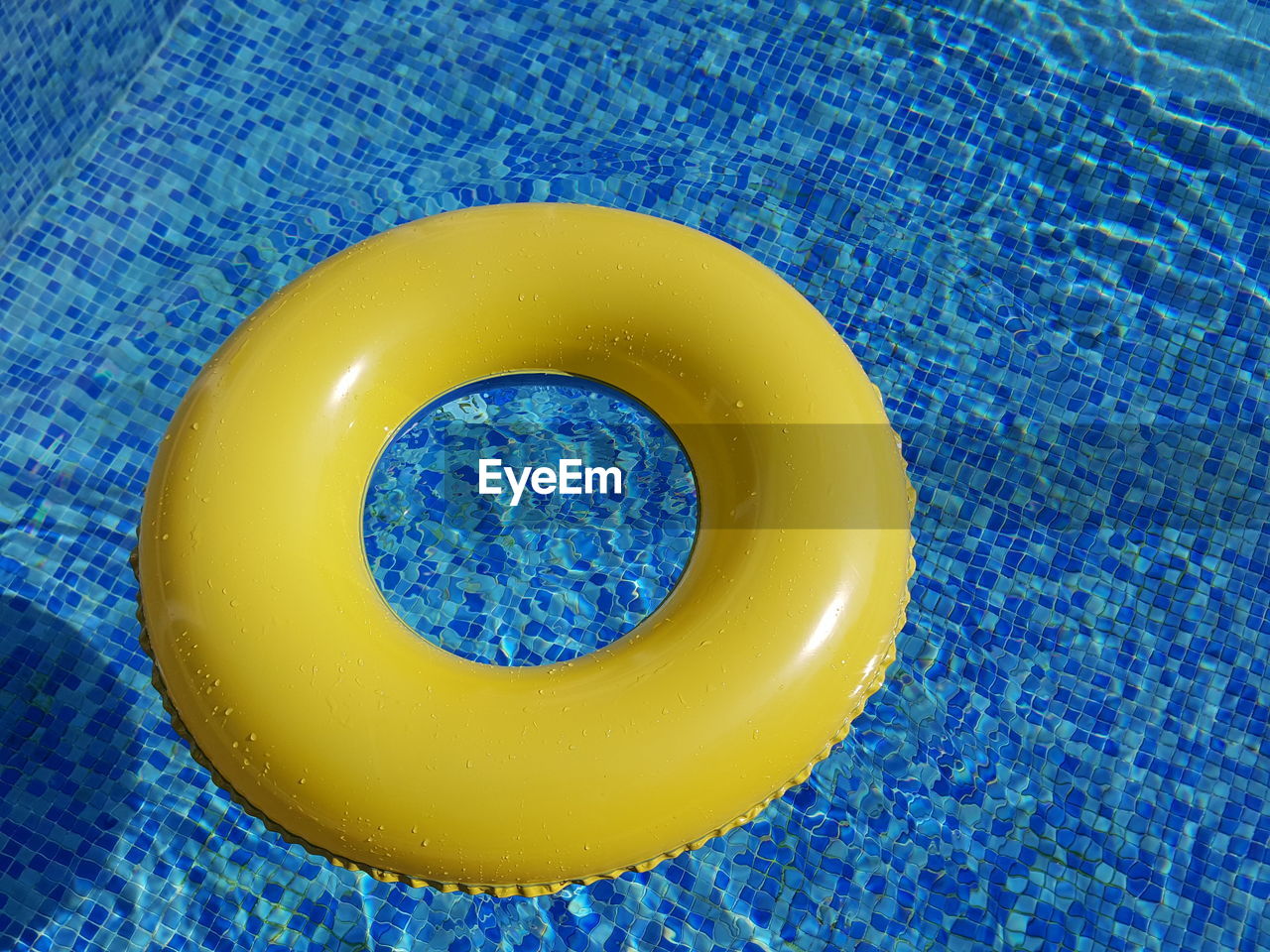 High angle view of yellow inflatable ring in swimming pool